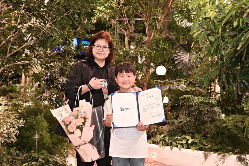 정태운 군과 그의 어머니가 부천시로부터 모범 어린이 표창장을 받은 뒤 환하게 웃고 있다./사진=부천시 제공,<a href=