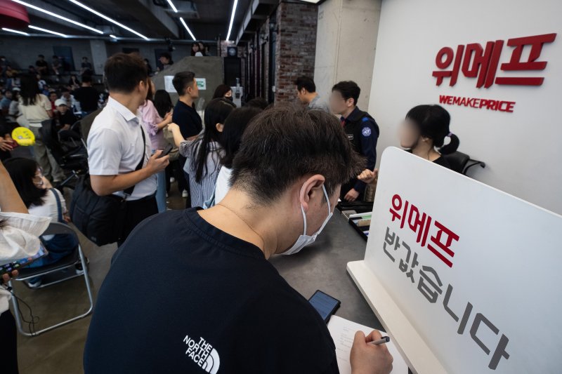 Customers at WeMakePrice headquarters in Gangnam-gu, Seoul, filling out refund request forms due to the 'payment delay incident' on July 25, 2024. News1