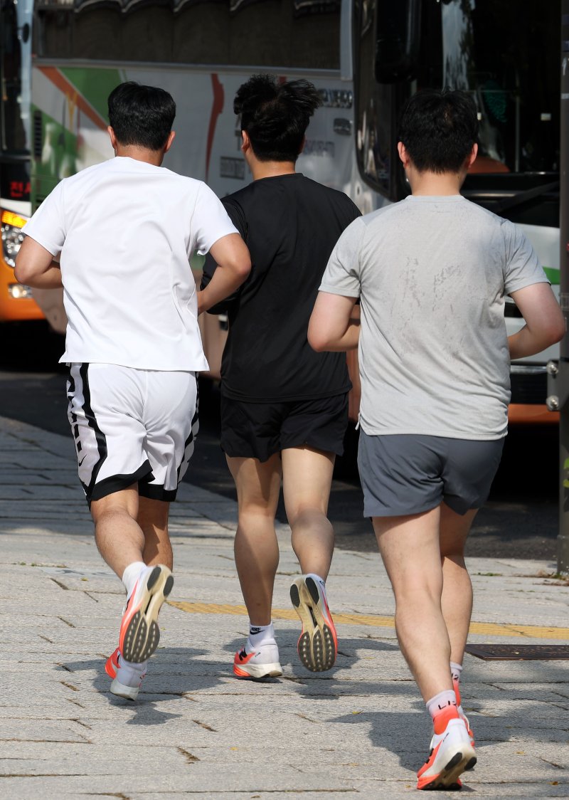 서울 종로구 경복궁 인근에서 시민들이 반바지와 반팔 차림으로 러닝하고 있다. 뉴시스