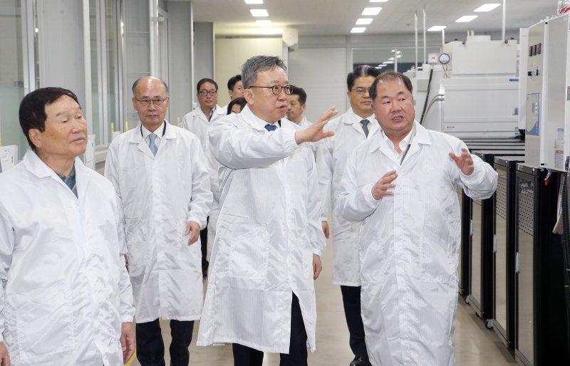 정상혁 신한은행장(앞줄 가운데)이 지난달 30일 경기 화성 디와이피 화성공장을 방문해 디와이피 홍순겸 회장(앞줄 왼쪽), 양준규 사장(앞줄 오른쪽)으로부터 설명을 듣고 있는 모습. 신한은행 제공