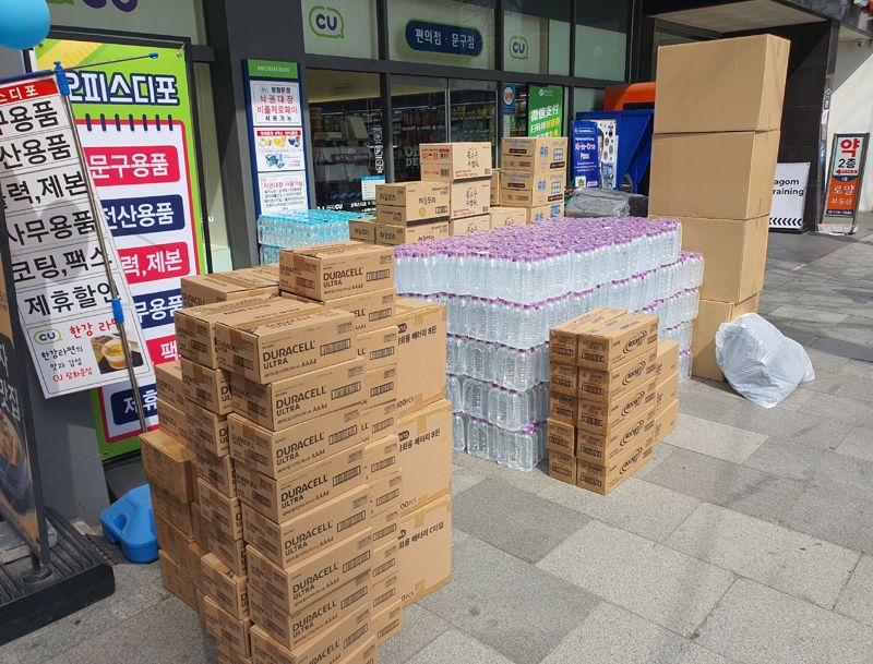 23일 오후 광화문 인근 한 편의점 앞에 BTS 공연 이후 반품을 앞둔 생수와 건전지 등이 박스 단위로 쌓여 있다. 공연 수요를 예상해 대량 발주했지만 인파 통제로 유입이 제한되면서 재고 부담이 발생한 모습이다. 사