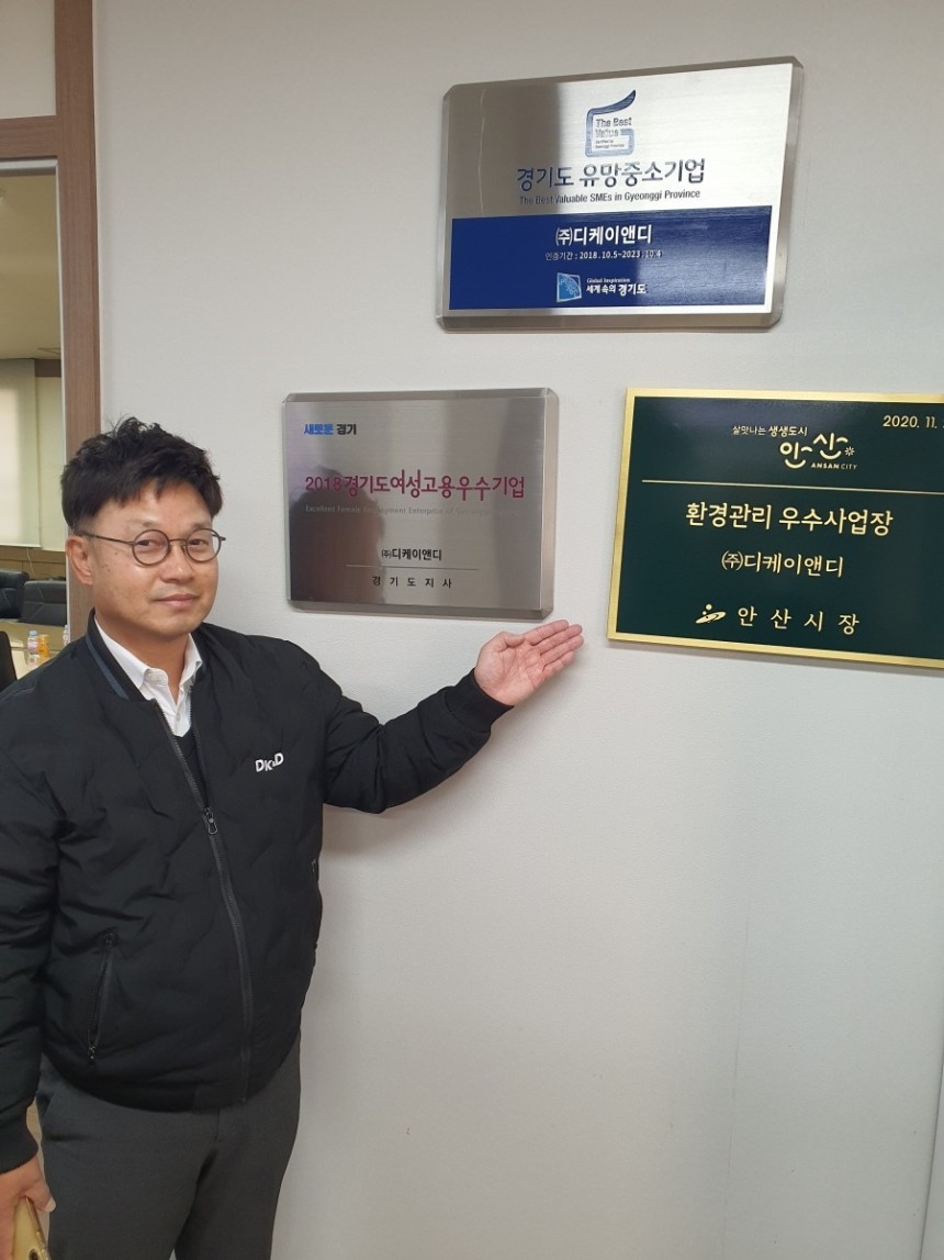 석동윤 이사가 경기도여성고용우수기업 인증 상패 등을 가리키고 있다.