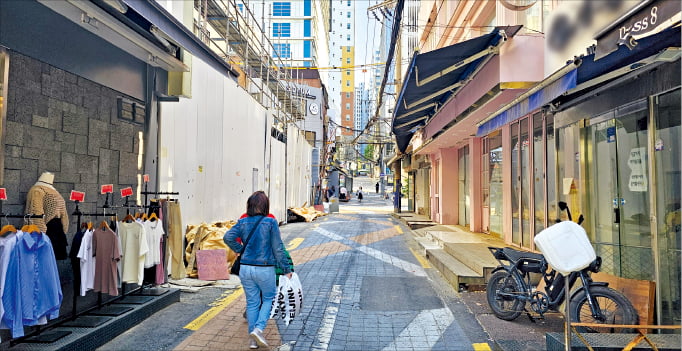 5일 서울 &#65279; 이화여대 앞 골목에서 폐업한 매장들 사이로 한 시민이 지나가고 있다.권용훈 기자