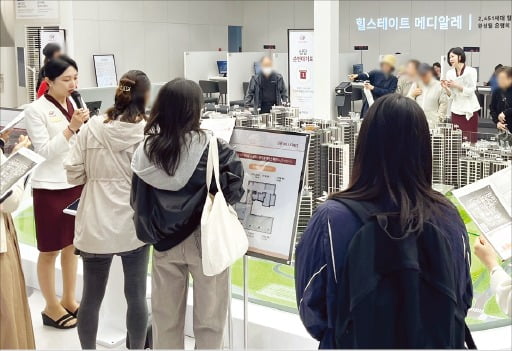 같은 날 개관한 은평구 '힐스테이트 메디알레' 견본주택 내부 모형 앞에서 방문객이 도우미의 설명을 듣고 있다./현대건설 제공