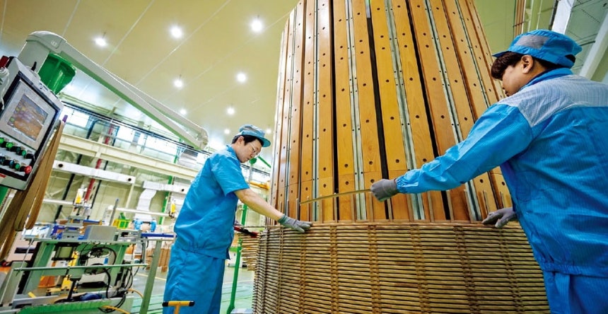 LS일렉트릭 직원들이 초고압직류송전(HVDC) 변압기에 들어가는 권선을 수직 권선기에 감고 있다. 권선은 전류를 흘려 자기장을 만드는 구리선 코일로, 변압기 내부에서 전압을 변환하