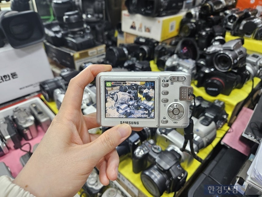 지난 5일 오후 5시 30분경 서울 종로구 세운상가 내 카메라 판매점에서 직접 빈티지 디지털카메라 전원을 켜고 사진을 찍으며 제품을 둘러보고 있다. /사진=박수빈 기자