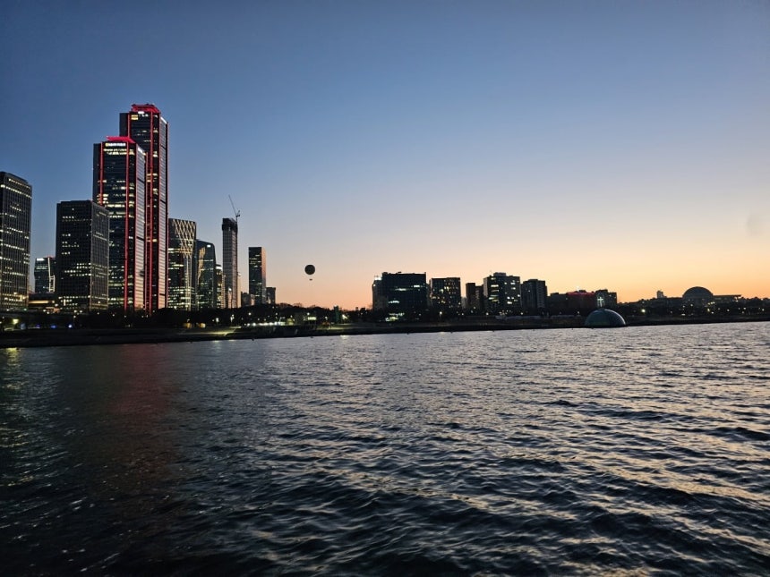 7일 오후 서울 여의도 한강버스 선착장에서 망원 방면으로 운항하던 배 위에서 바라본 한강 야경. 여의도 일대 빌딩 숲과 노을빛 하늘이 강물 위로 비치고 있다. 권용훈 기자