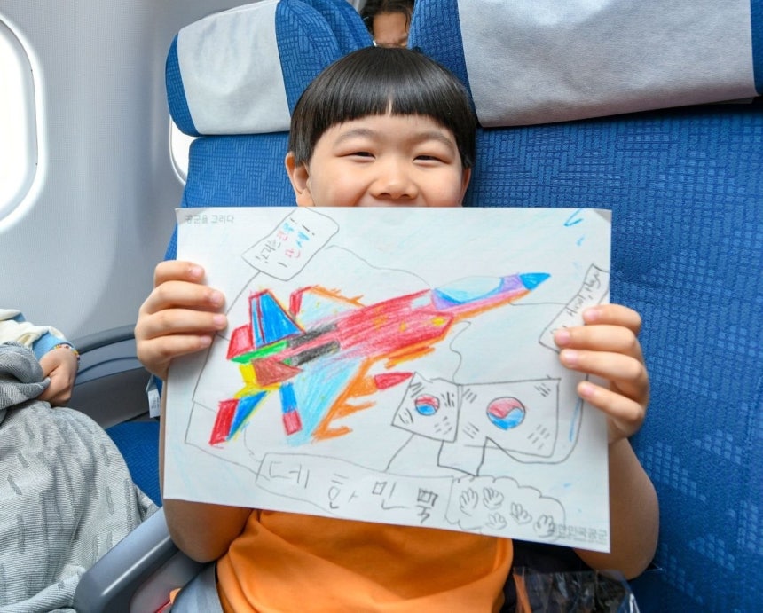 15일 공군 수송기(KC-330)에 탑승한 어린아이가 스케치북으로 그림을 그리고 있다./사진=뉴스1