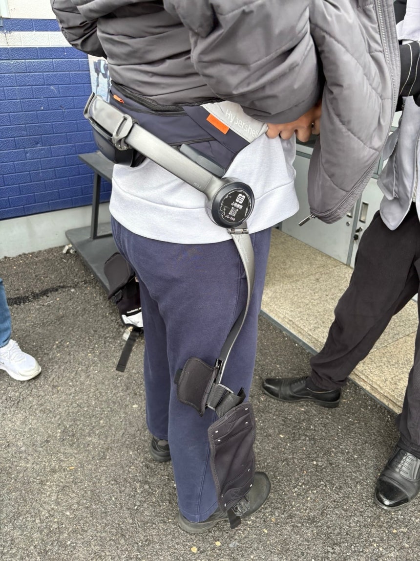 지난 25일 중국 지린성 백두산 천지로 향하는 계단 아래 외골격 웨어러블 로봇 대여소에서 관광객들이 제품을 착용하고 있다. 한 번 대여료는 98위안으로 허리와 양쪽 허벅지에 장치를 착용하면 센서가 보행을 감지해 오르