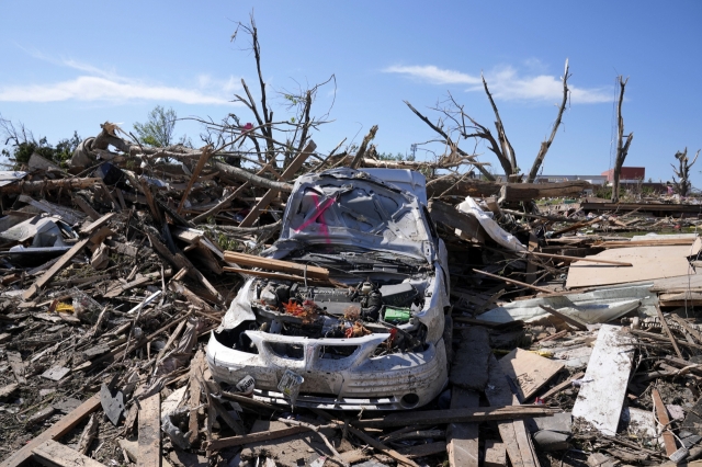 Cars and debris damaged by a tornado. [AP]