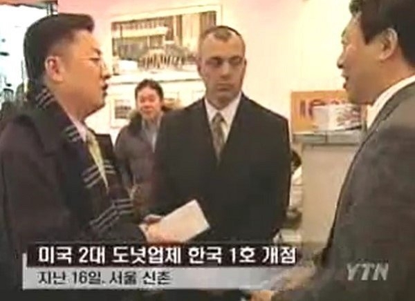 크리스피크림도넛의 국내 1호점인 신촌점 개장 당시 신동빈(오른쪽) 롯데 부회장이 밝게 웃으며 대화하고 있다. [YTN 뉴스 캡처]