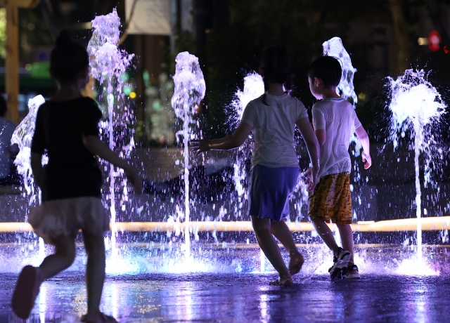 Children playing in the water at Gwanghwamun Square, Jongno-gu, Seoul in the afternoon of the 5th when the tropical nights were prevailing. Yonhap News