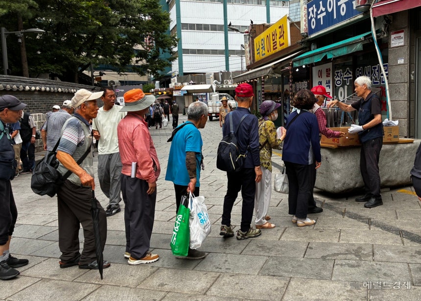 13일 오전 8시께 서울 종로구 원각사 무료급식소에서 아침 주먹밥을 받기 위해 줄을 서 있는 시민들의 모습.김서현 수습기자