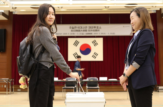 A voter placing a voting slip into a ballot box at the South Korean Embassy in Minato, Tokyo, on the first day of overseas voting for the 21st presidential election on the 20th.
