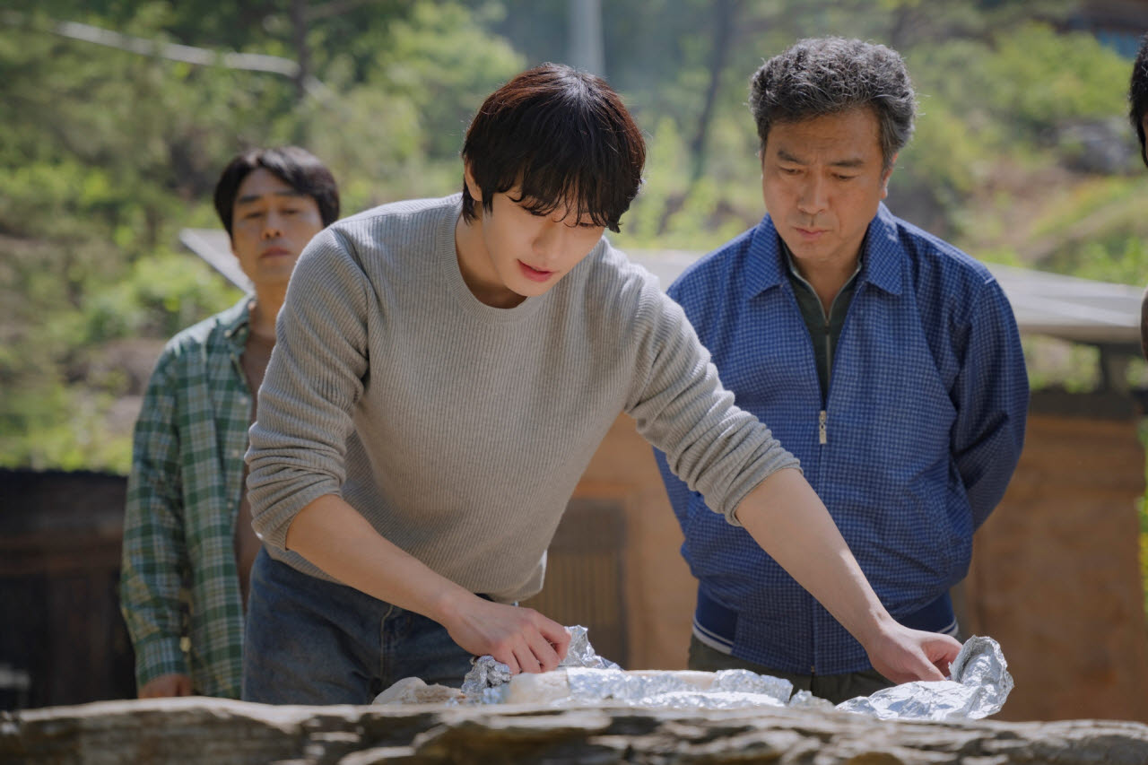 野外で料理をするアン・ヒョソプと、そばで見守る共演者たち