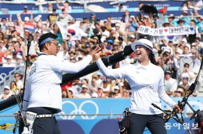 김우진(왼쪽)과 임시현이 2일 파리 올림픽 양궁 혼성전 결승에서 독일을 물리치고 금메달을 따낸 뒤 승리를 자축하는 하이파이브를 하고 있다. 앞서 이번 대회 남녀 단체전에서 각각 우승한 두 선수는 2관왕에 올랐다. 파