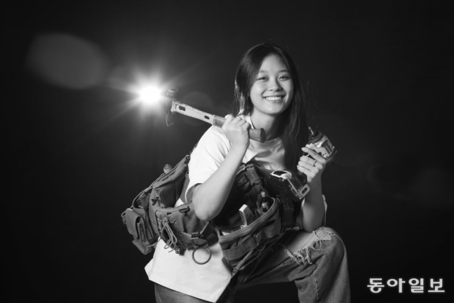 목조주택 빌더(목수) 이아진 씨가 자신이 현장에서 쓰는 공구를 들고 활짝 웃고 있다. 아진 씨는 호주에서 고등학교를 자퇴한 뒤 귀국해 목수로 일하면서 자신의 성장 과정을 유튜브로 공개해 14만 명이 넘는 구독자를 보