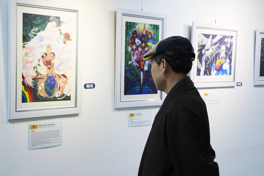 전시장을 방문한 시민들이 평화사랑 그림그리기 국제대회 수상작을 감상하고 있다.