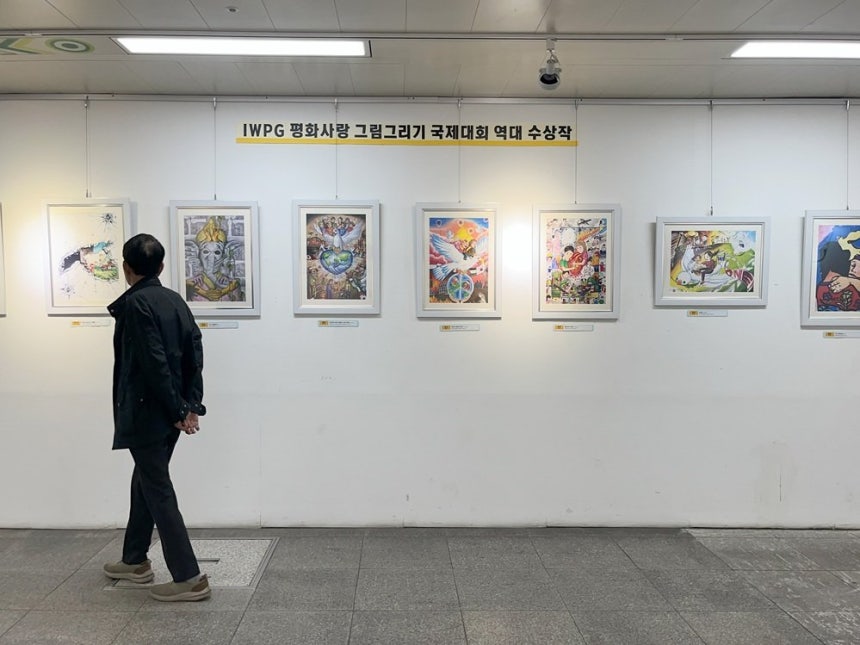 전시장을 방문한 시민들이 평화사랑 그림그리기 국제대회 수상작을 감상하고 있다.