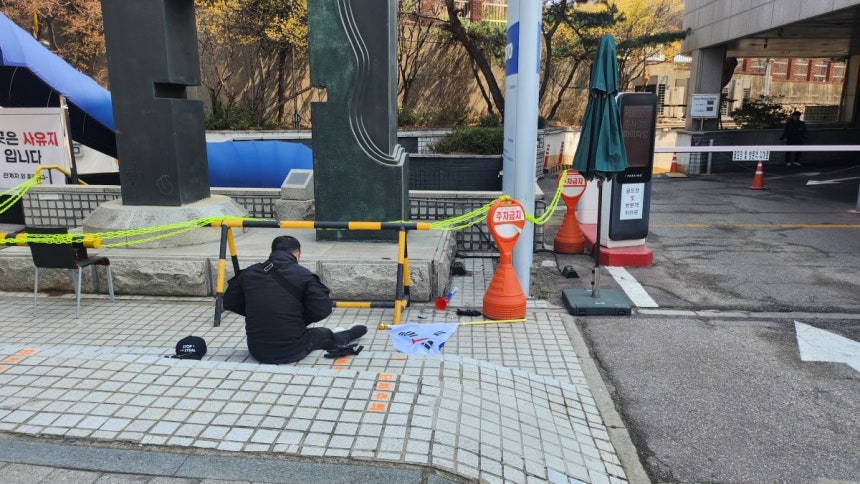 태극기를 던지고 담배를 피우는 윤 전 대통령 지지자. 최재호 기자 cjh1225@donga.com