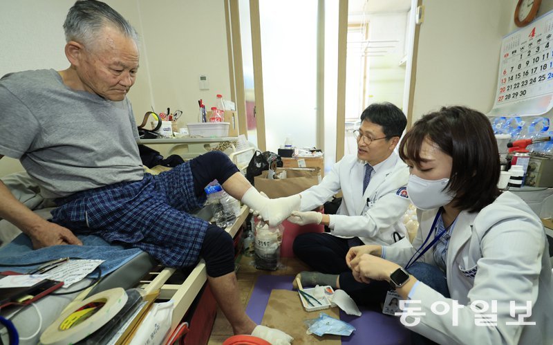 지난달 3일 광주 서구 김영준 씨(왼쪽) 자택에 서해현 시니어통합의원 원장(가운데)과 김하진 간호사가 방문해 당뇨 합병증으로 괴사된 김 씨의 발을 소독하고 있다.장기요양 4등급인 김 씨는 광주 서구의 통합돌봄 시범