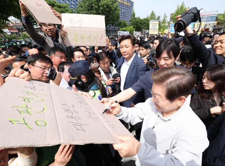  지지자들 “공판 연기 환영”에 李 “맞습니다” 더불어민주당 이재명 대선 후보가 7일 전북 전주시 완산구 풍남문 앞 광장에서 이 후보의 공직선거법 위반 사건 파기환송심 공판기일 변경을 환영하는 지지자의 응원 피켓에 