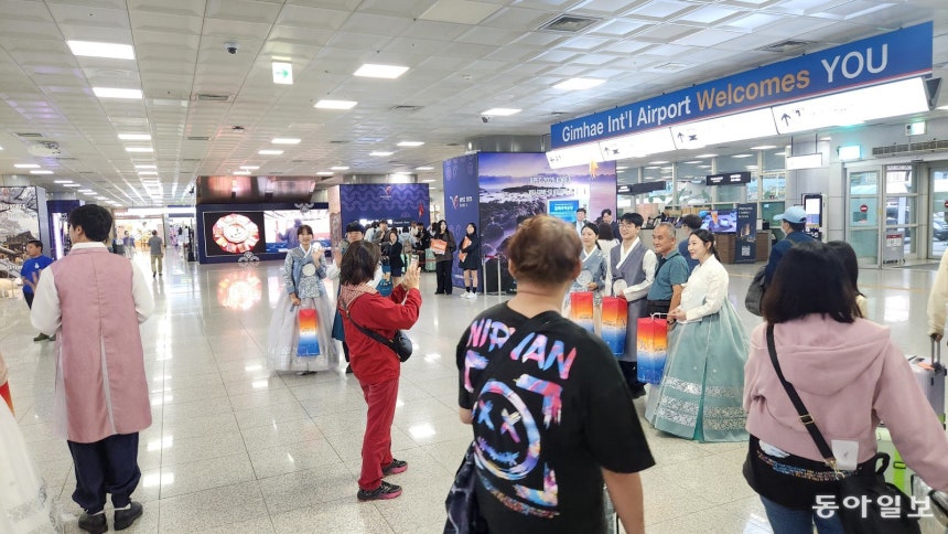 25일 부산 강서구 김해국제공항 국제선 청사 입국장에서 외국인 관광객이 한복을 입은 청년들과 함께 기념사진을 찍고 있다. 부산=김화영 기자 run@donga.com