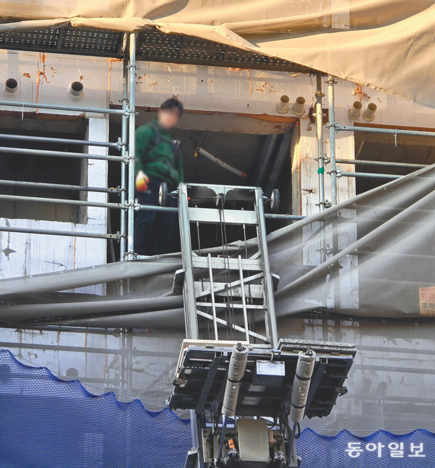 지난달 11일 서울 마포구의 한 공동주택 건설 현장에서 현장 노동자가 안전모와 안전고리 없이 4층 높이에서 하역 작업을 하고 있다. 고층 작업 시 노동자는 추락 방지를 위해 반드시