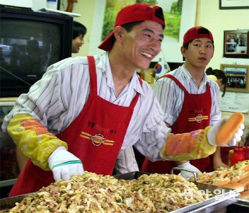 영철버거 대표 이영철 씨(왼쪽)가 고려대 학생들에게 판매할 안암동 명물 스트리트버거를 만들어주는 모습.동아일보DB