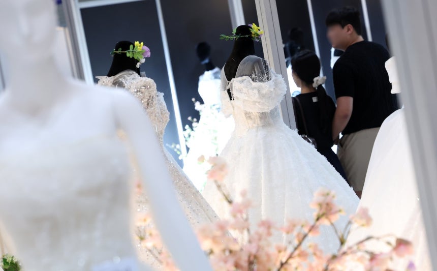 지난 7월 6일 서울 강남구 삼성동 코엑스에서 열린 2025 추계 웨덱스 웨딩 박람회에서 예비 부부들이 전시된 드레스를 살펴보고 있다. 2025.7.6 뉴스1