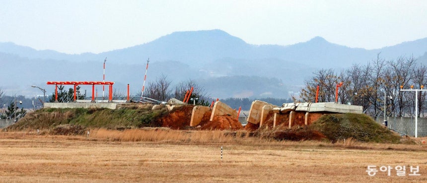  12·29 무안공항 제주항공 여객기 참사 1주년을 나흘 앞둔 25일,전남 무안군 무안국제공항 활주로 바깥의 콘크리트 둔덕이 일부 무너져 있다.국토교통부는 당시 피해를 키웠던 이 둔덕을 포함한 전국 7개 공항의 