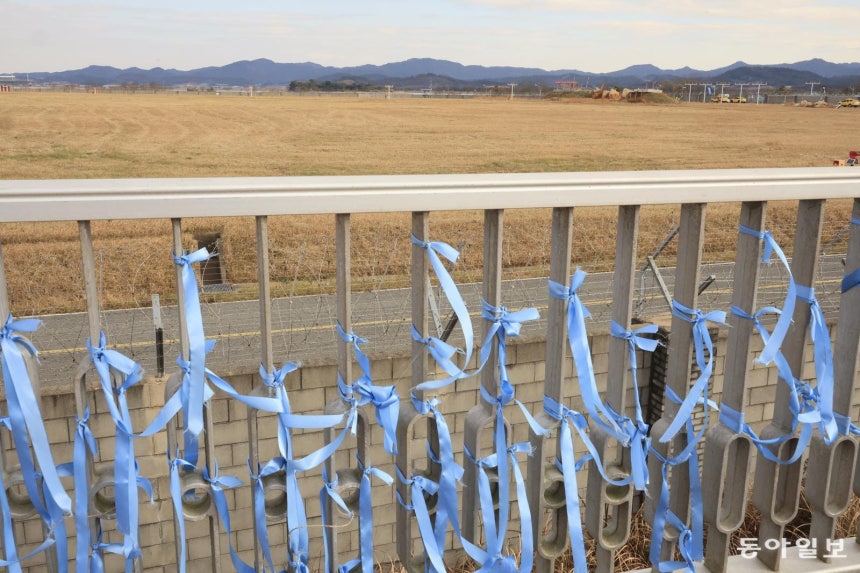 제주항공 참사 1주기를 하루 앞둔 전남 무안공항 사고 현장이 보이는 활주로 전망대에 추모 현수막과 파란 리본이 걸려 있다.무안=박영철 기자 