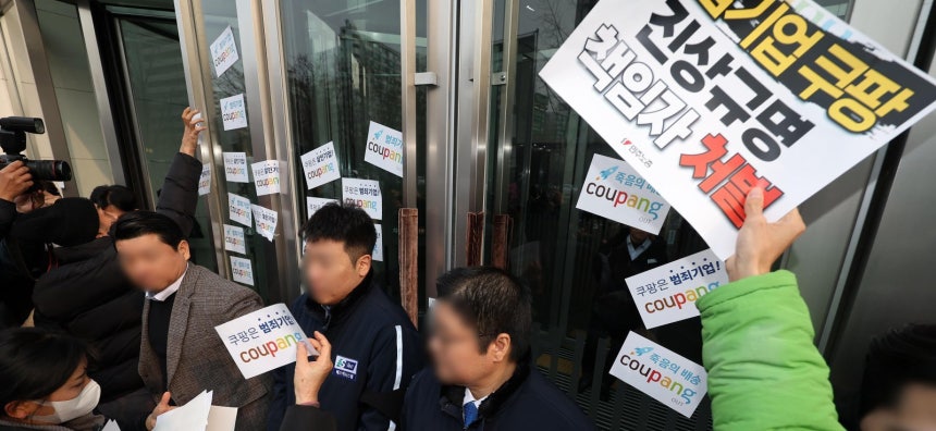  29일 서울 송파구 잠실 쿠팡 본사 앞에서 전국민주노동조합총연맹(민노총),쿠팡 산재사망노동자 유가족 등이 건물 출입문에 진상 규명과 책임자 처벌 등을 촉구하며 쿠팡을 비판하는 내용을 담은 스티커를 붙이고 있다.