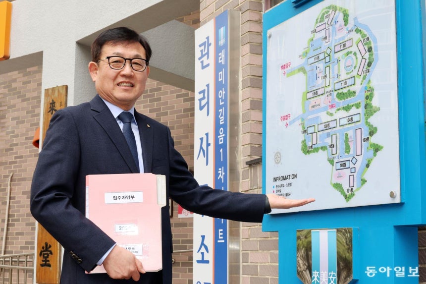 이종호 서울 성북구 래미안길음 1차 아파트 관리소장이 관리사무소 앞에서 단지 조감도를 가리키고 있다.SC제일은행 서대문 지점장을 끝으로 명예퇴직한 그는 개인 사업,중소기업 임원 등을 하다 2019년 주택관리사 자