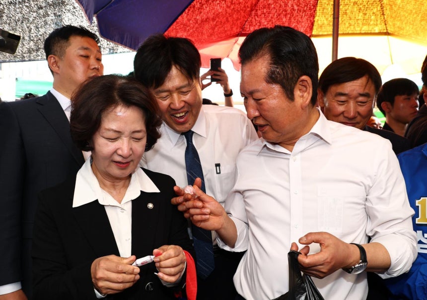 정청래 더불어민주당 대표가 19일 오후 경기 성남시 모란시장 민속5일장에서 김용 전 민주연구원 부원장에게 사탕을 건네고 있다. 2026.04.19. [서울=뉴시스] 