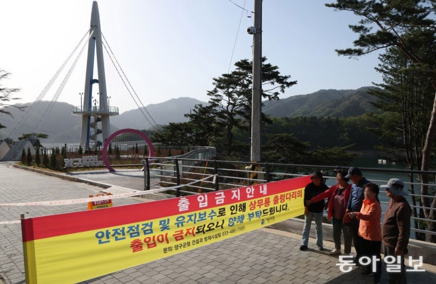 강원 양구읍 월명리와 상무룡리를 파로호 건너 잇는 상무룡출렁다리가 안전상의 이유로 재개통 기한 없이 한 달 넘게 관광객 통행이 금지돼 있다. 배를 타고 파로호를 건너온 상무룡리 주민들이 출입 통제 플래카드를 보며 한