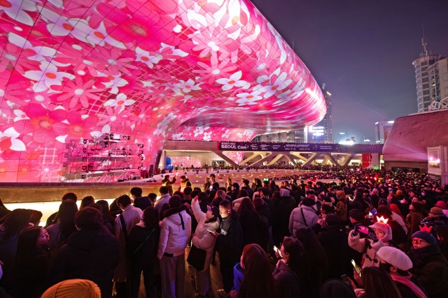 지난해 ‘서울라이트 DDP 2023 겨울’을 찾은 방문객들이 거대한 외벽을 캔버스 삼아 자연의 모습을 구현한 초대형 미디어파사드 쇼를 관람하고 있다. /서울디자인재단
