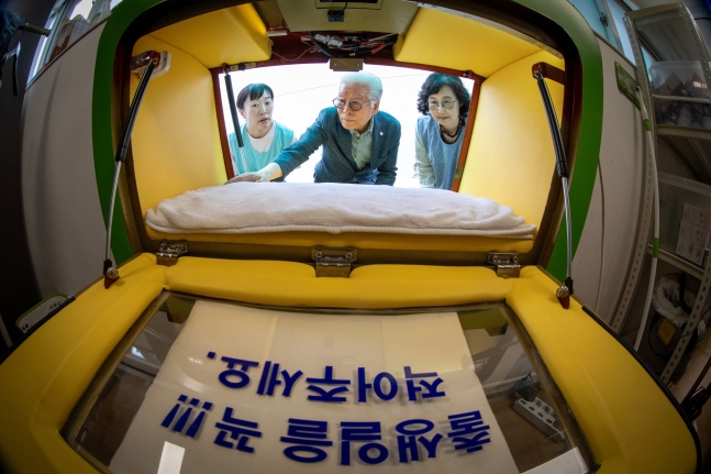 베이비박스 설립자 이종락 목사(가운데)와 관계자들이 20일 서울시 관악구 난곡로 소재 재단법인 주사랑공동체 담벼락에 설치된 베이비박스 내부를 살펴보고 있다. 산모가 아이를 베이비박스에 맡기려면 이름과 생년월일 등 간