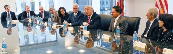 Donald Trump, former president, chatting with Silicon Valley IT industry personnel at Trump Tower in New York shortly after his election in December 2016. The person sitting directly to Trump's right is Peter Thiel, co-founder of PayPal. / AFP News1
