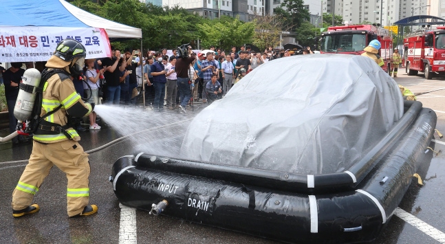 Demonstration of electric vehicle fire suppression - Firefighters demonstrate extinguishing electric vehicle fire using asphyxiation fire extinguisher and tank for electric vehicle at a joint civil-military education event held at the Songdo 2-dong administrative welfare center parking lot in Yeonsu-gu, Incheon on the 13th. After a Mercedes-Benz electric car fire incident in Cheongna, Incheon earlier this month raised consumer anxiety about electric car batteries, automotive companies have been releasing battery manufacturer information one after another. /Yonhap