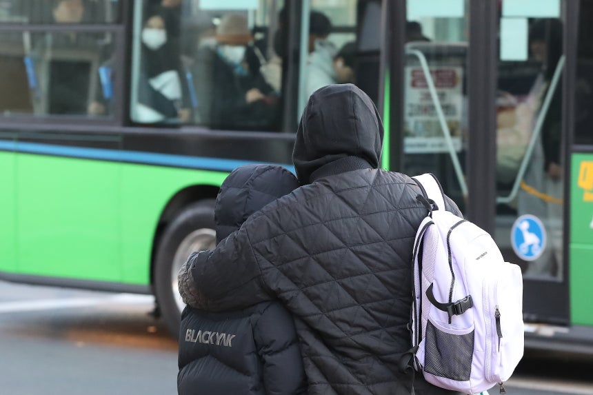 찬바람과 함께 기온이 크게 내려간 16일 오전 경북 경산역 앞에서 두꺼운 외투를 챙겨 입은 학생과 엄마가 꼭 끌어안은 채 보행자 신호를 기다리고 있다. /뉴스1
