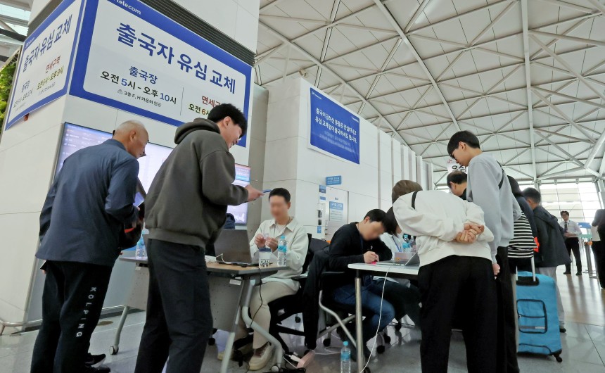 6일 오전 인천국제공항에 설치된 SKT 부스를 찾은 여행객들이 출국에 앞서 유심을 교체하고 있다./ 뉴스1