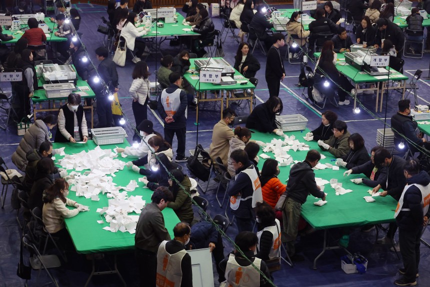 부산교육감 재선거가 치러진 지난 4월 2일 한 개표소에서 사무원과 참관인(흰 조끼 입은 이들)이 개표 업무를 하고 있다.이처럼 선거 때마다 일시 인력이 대거 채용된다./연합뉴스 
