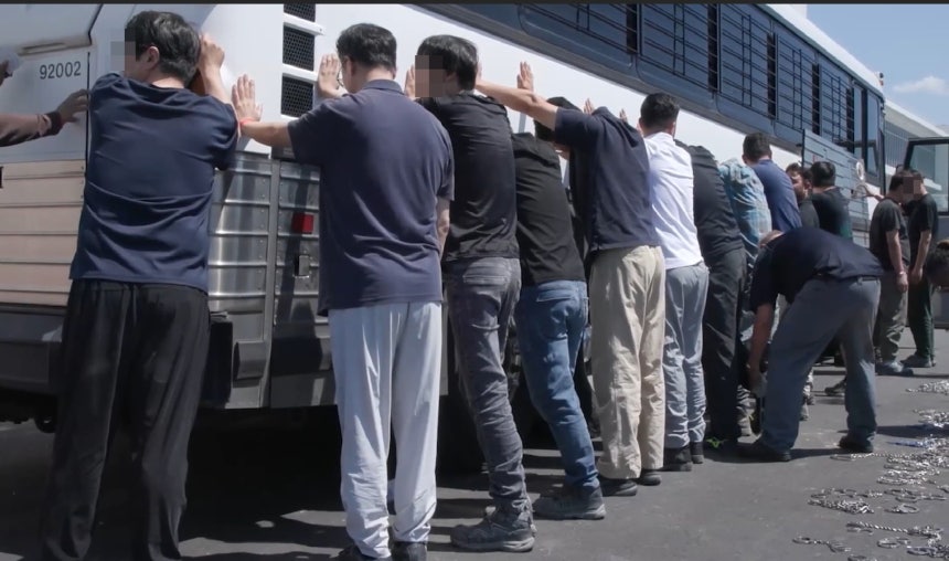 5日、米国移民税関取締局(ICE)がホームページに公開したジョージア州現代車とLGエネルギーソリューションが共に建設中の電気自動車バッテリー工場建設現場の取締り現場、鎖で縛っていく姿も見られる。