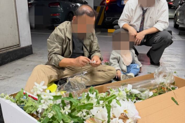 A씨의 아버지가 결혼식장 주차장에서 부케를 만들고 있는 모습. /스레드