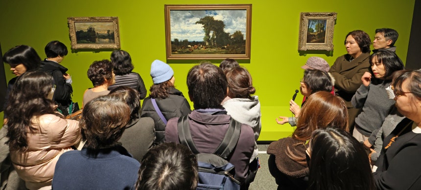 19일 서울 용산구 국립중앙박물관 ‘인상주의에서 초기 모더니즘까지, 빛을 수집한 사람들’ 전시에서 관람객들이 도슨트의 설명을 듣고 있다. 가운데 그림은 ‘소 떼가 있는 리무쟁의 풍경’./장경식 기자