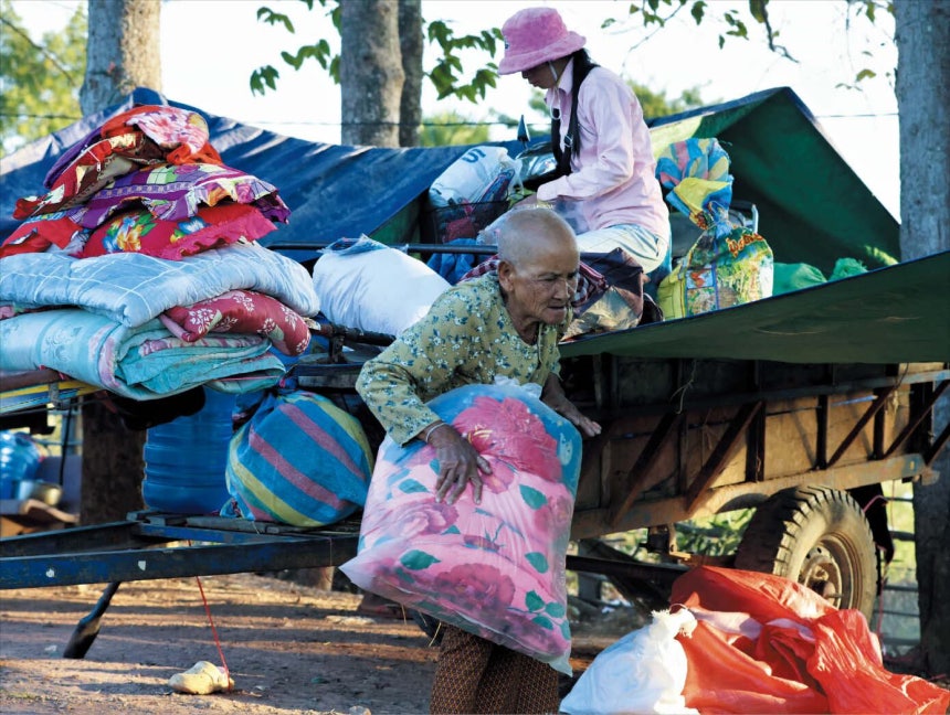  신화 연합뉴스고달픈 피란살이 8일 캄보디아 시엠레아프주의 임시 수용소에서 피란민들이 짐을 옮기고 있다.휴전에 합의했던 태국과 캄보디아가 교전을 재개하면서 수십만 명의 피란민이 발생했다.