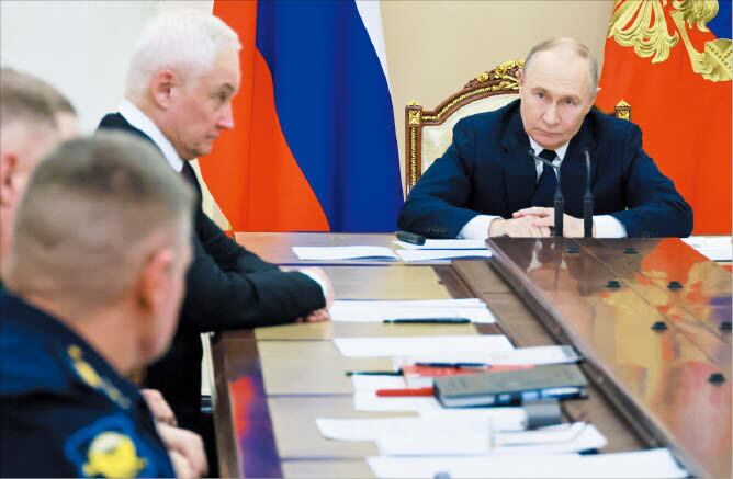 블라디미르 푸틴(오른쪽) 러시아 대통령이 29일 모스크바 크렘린궁에서 안드레이 벨로우소프(왼쪽) 국방장관 등이 참석한 고위 군 지휘관 회의를 주재하고 있다./AP 연합뉴스