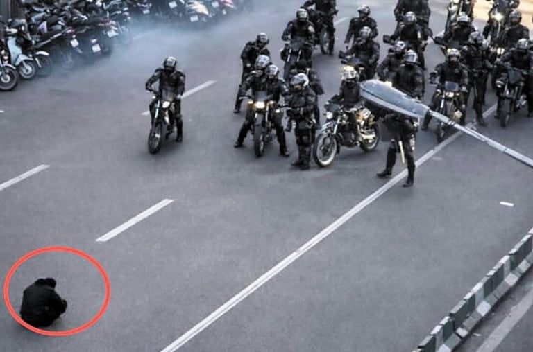 청년들의 대규모 반정부 시위가 확산 중인 이란 수도 테헤란에서 도로에 웅크리고 앉은 남성이 시위 진압을 위해 이동하던 경찰 오토바이 행렬을 막아서고 있다.1989년 중국 천안문 시위 당시 전차를 맨몸으로 가로막았던