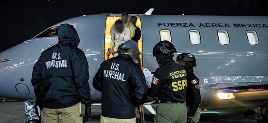 미 연방 요원 등이 죄수복을 입고 포승줄에 묶인 멕시코 마약 범죄 조직원들을 수송기를 통해 호송하고 있다.이들은 시날로아 카르텔 등 멕시코 주요 마약 조직의 핵심 인사들이다./미 법무부